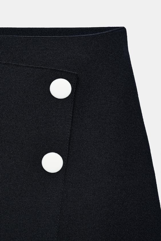 Jupe courte en maille à boutons contrastés