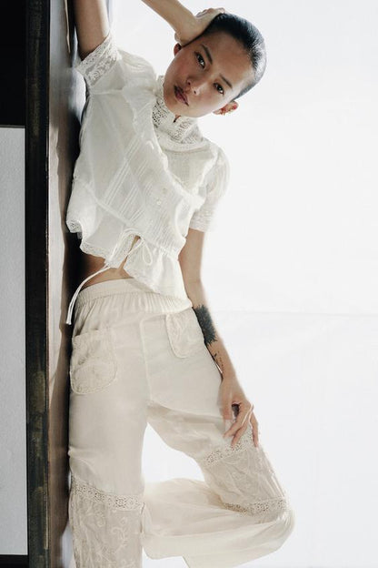 Pantalon contrasté à dentelle et broderies florales
